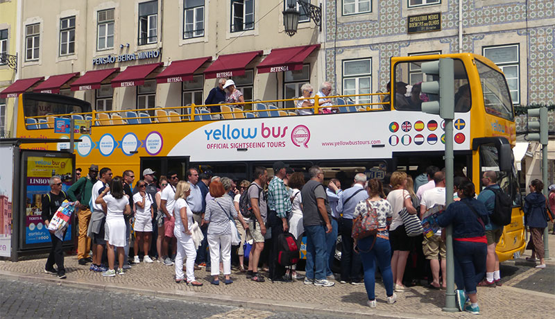 Grote groep toeristen bij panoramabus in Lissabon